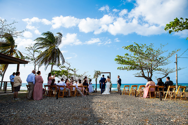 "Pareja intercambiando votos en una boda al aire libre en Aguada, Puerto Rico."
