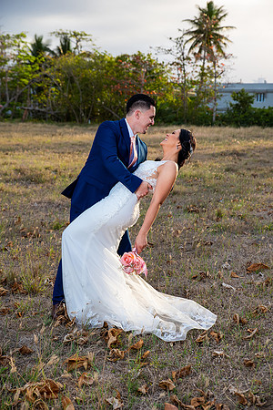 "Pareja de novios caminando en la orilla de la playa al atardecer."