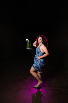 quinceañera en sesión de pre quince en el túnel de guajataca puerto rico con iluminación fucsia