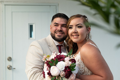 Recién casados posando en la playa con un atardecer dorado en Puerto Rico.
