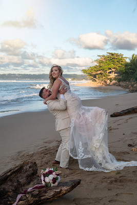 Recién casados posando en la playa con un atardecer dorado en Puerto Rico.
