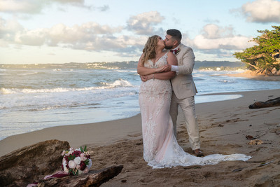Recién casados posando en la playa con un atardecer dorado en Puerto Rico.
