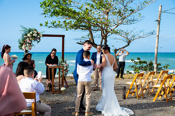 "Pareja intercambiando votos en una boda al aire libre en Aguada, Puerto Rico."