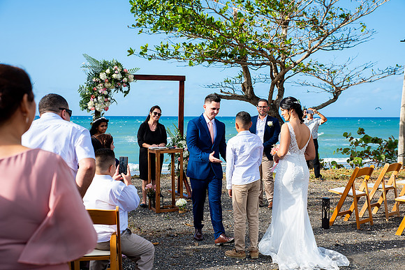 "Pareja intercambiando votos en una boda al aire libre en Aguada, Puerto Rico."