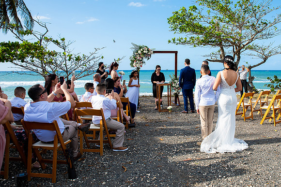 "Pareja intercambiando votos en una boda al aire libre en Aguada, Puerto Rico."