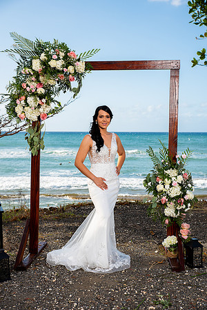 "Pareja de novios caminando en la orilla de la playa al atardecer."