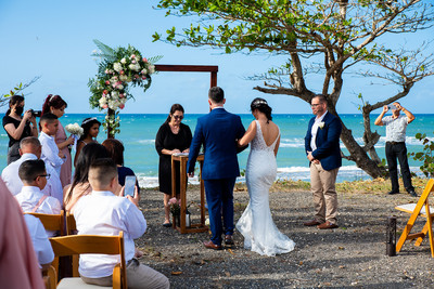 "Pareja intercambiando votos en una boda al aire libre en Aguada, Puerto Rico."