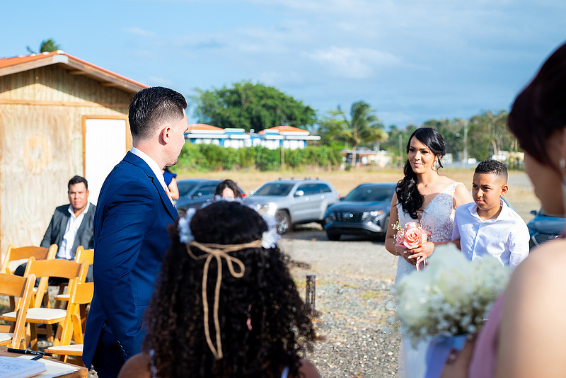 "Pareja intercambiando votos en una boda al aire libre en Aguada, Puerto Rico."