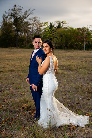 "Pareja de novios caminando en la orilla de la playa al atardecer."
